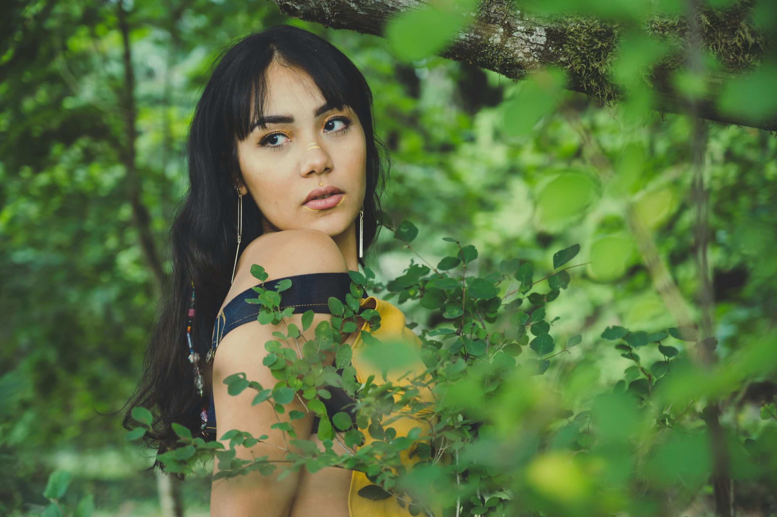 A model transformed into an ethereal forest nymph using green-toned eyeshadows and metallic accents