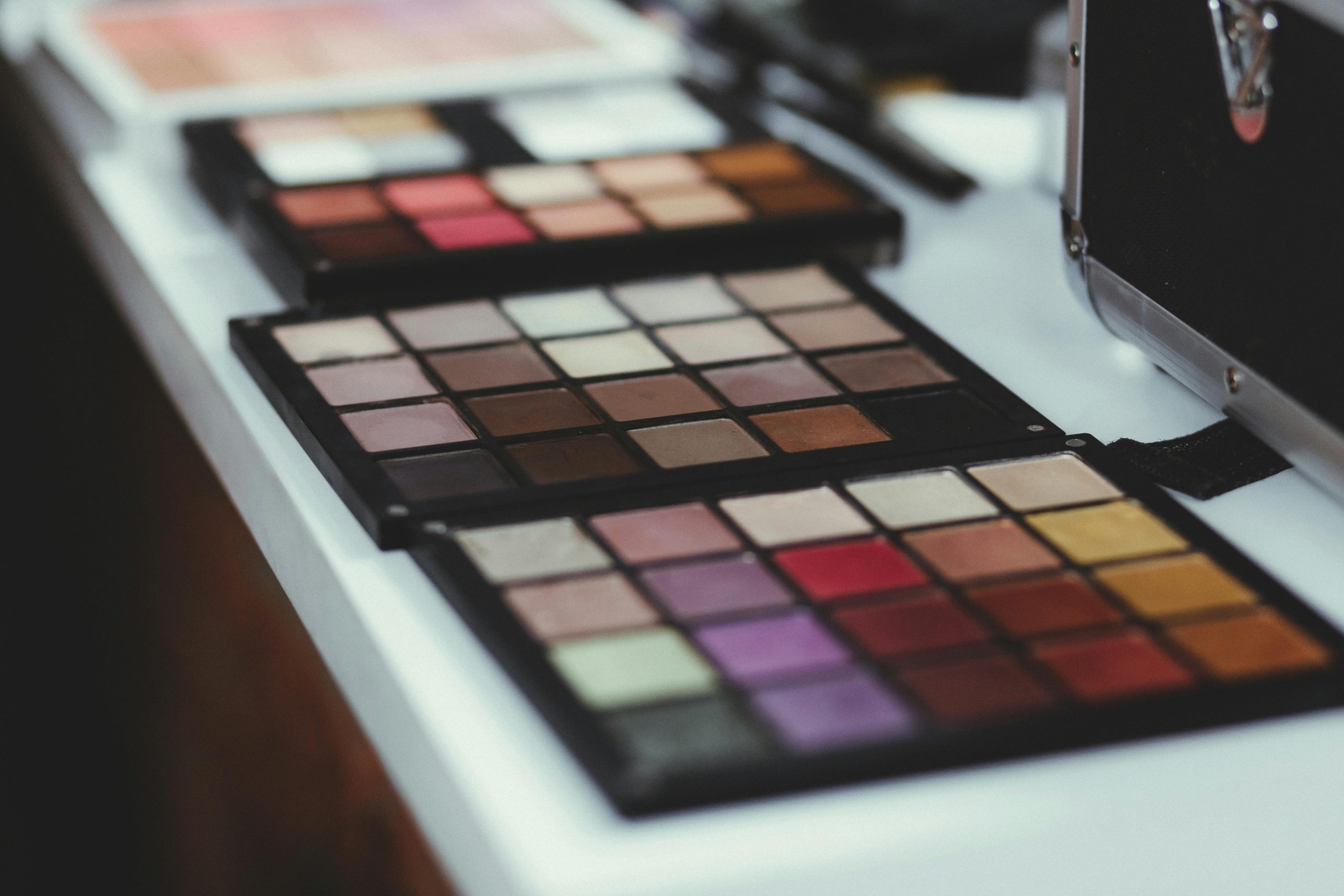 An array of makeup brushes, sponges, and colorful palettes laid out neatly