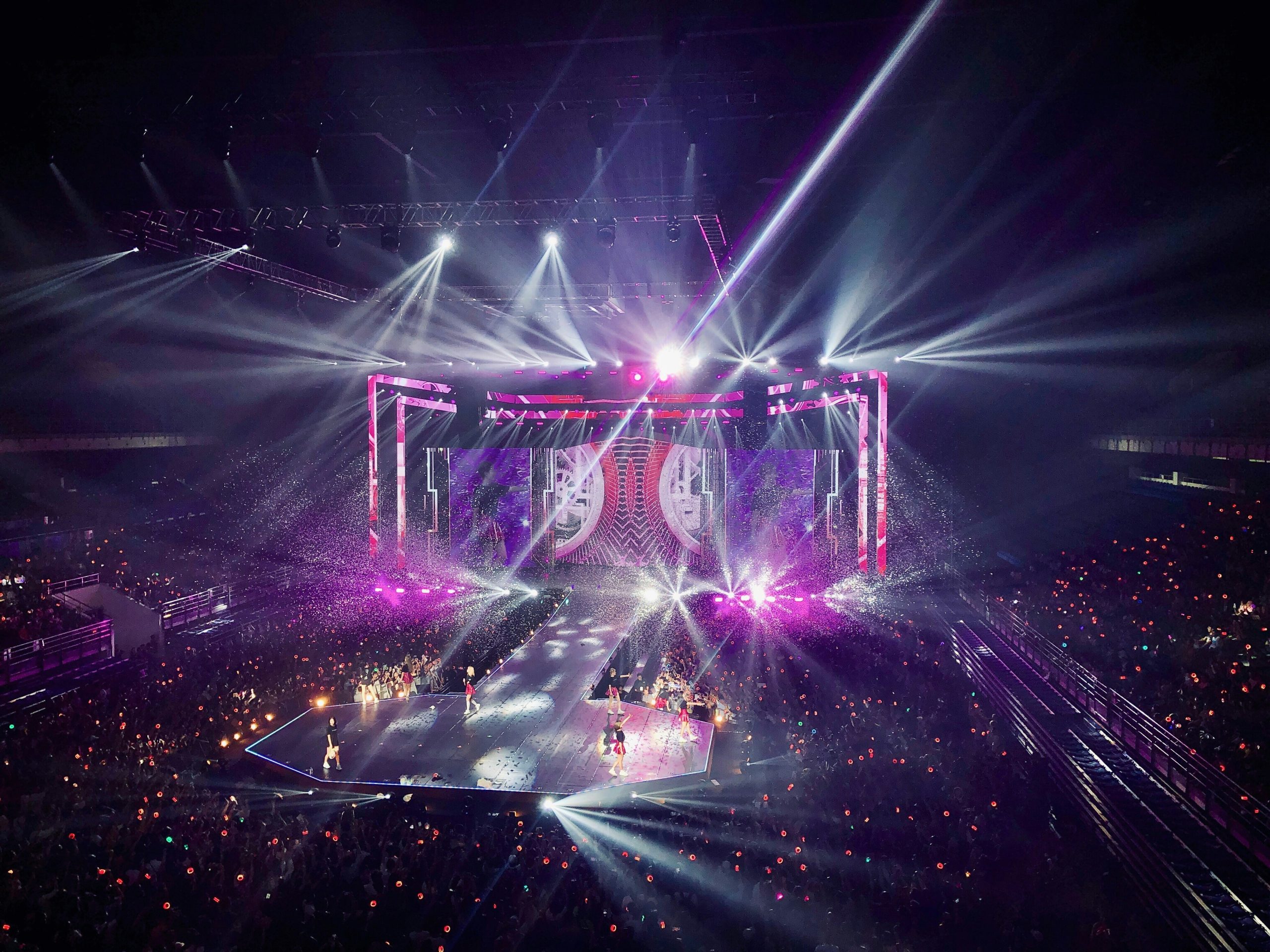 Bright stage lights shining down on a performer, highlighting their dramatic makeup.
