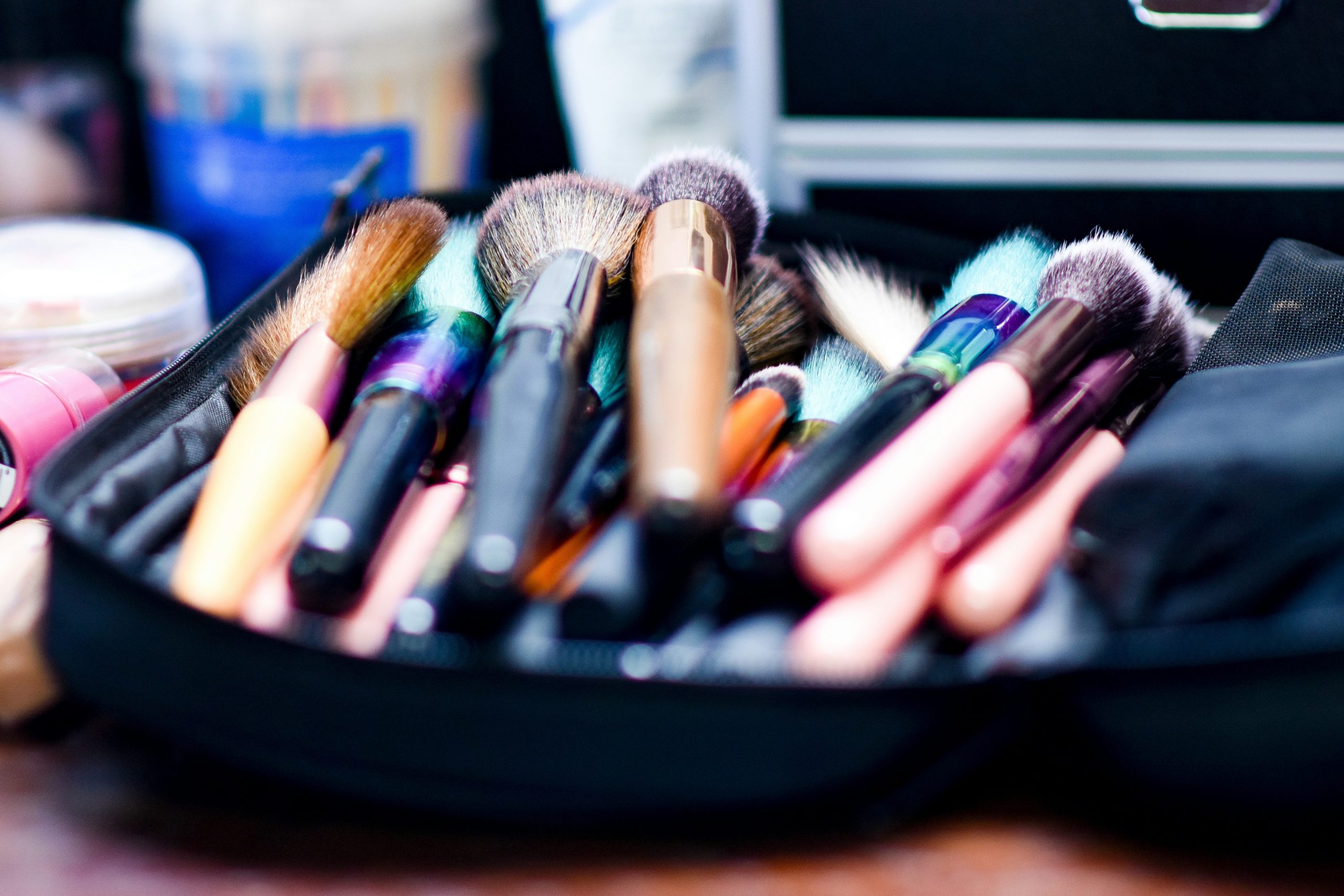 Person frowning while surrounded by makeup products and tools