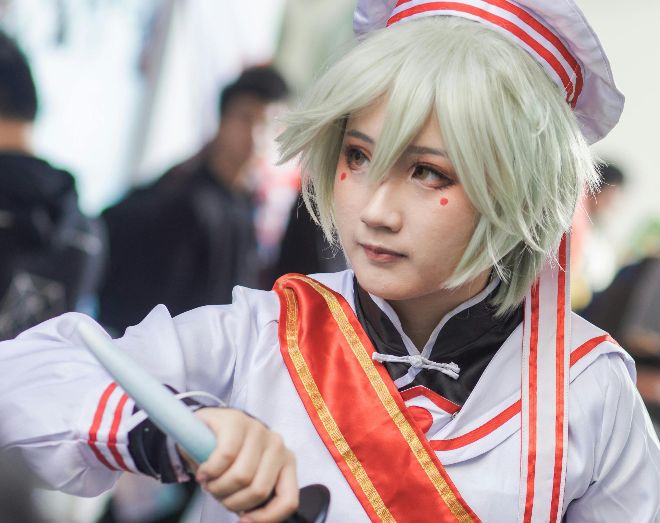 Photo of cosplayer dressed as anime character with vibrant pink hair and intricate eye makeup