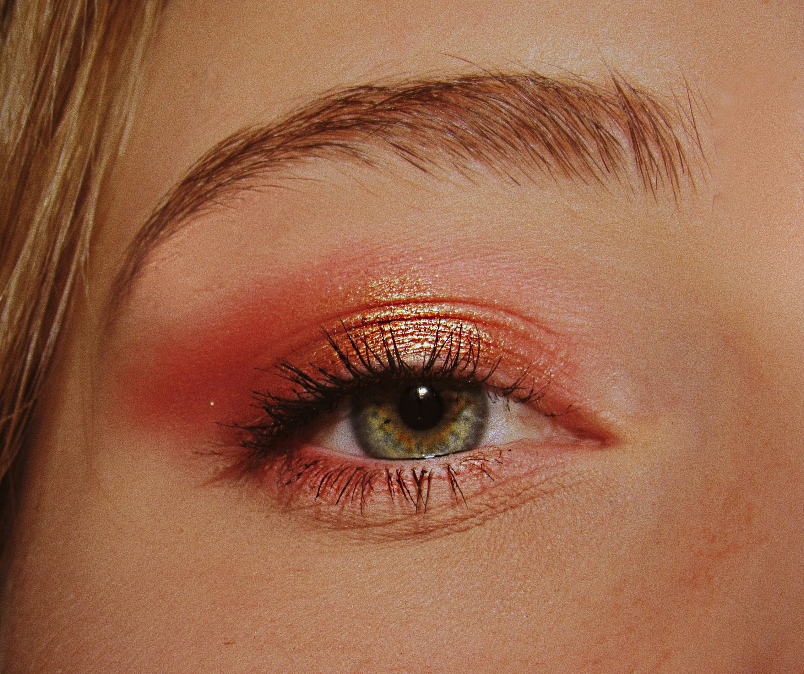 A model wearing dramatic Halloween makeup under bright spotlights