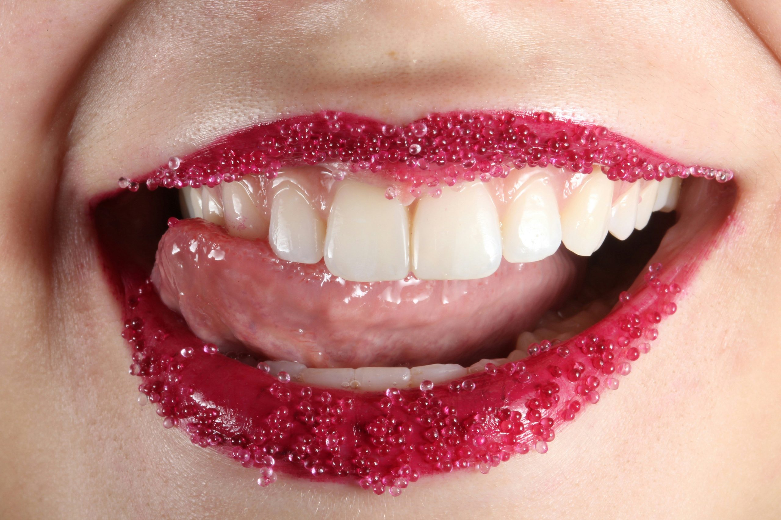 Close-up shot of lips painted deep burgundy with subtle black accents around the edges