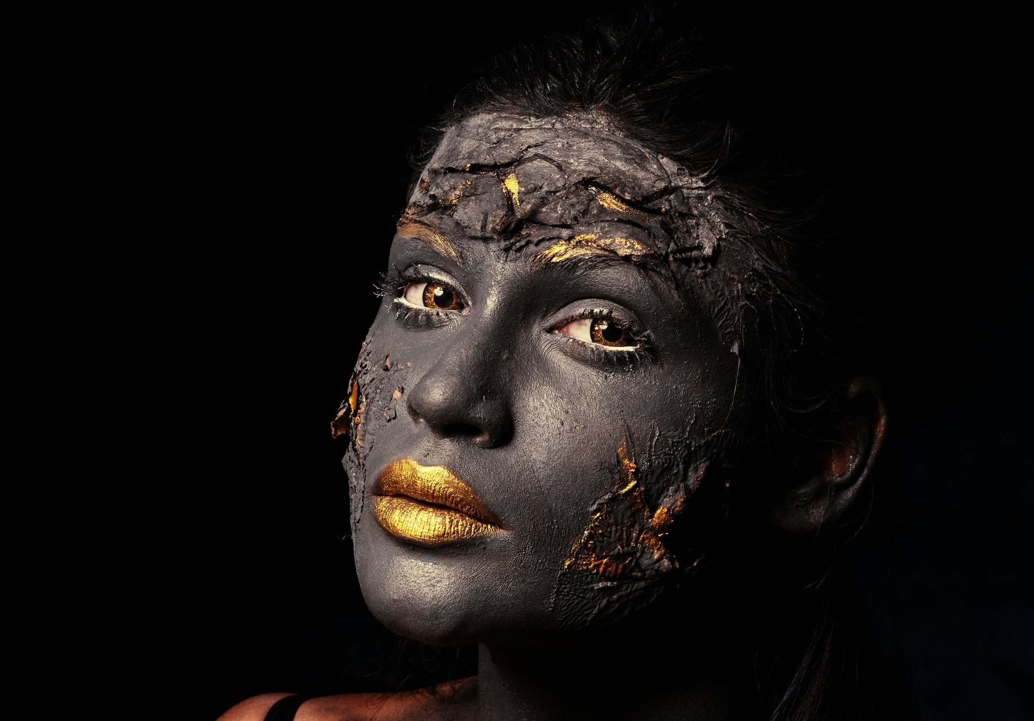 A woman in a tattered wedding gown with highly detailed fake wounds covering her face and arms