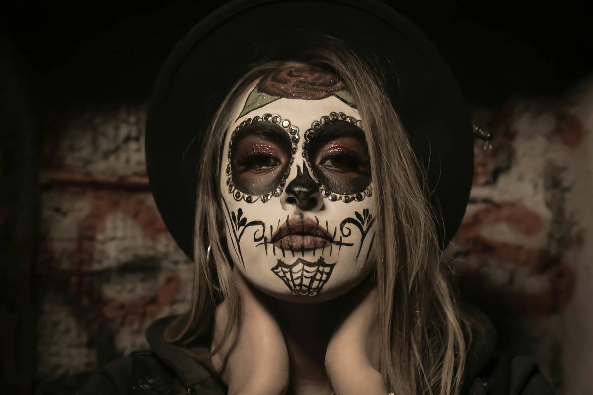 A detailed black-and-white skull design painted across a model's face