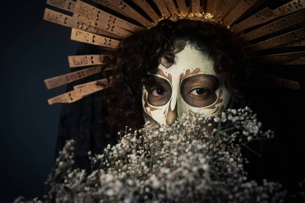 A close-up shot showing vibrant theater face paint being applied smoothly on someone's cheek.
